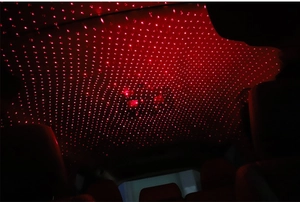 Car USB laser projector showing red starry sky lighting effect on vehicle interior roof