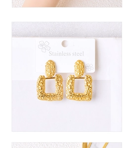 Detailed macro of gold square earrings featuring hammered texture and stainless steel finish