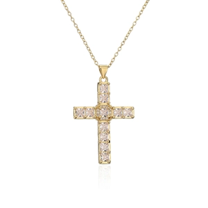 Macro shot of gold plated cross pendant with square and round cubic zirconia stones