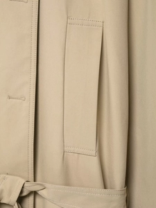 Detailed view of khaki trench coat fabric texture with professional stitching and belt loops