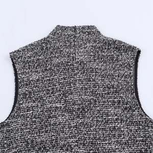 Détail de la texture en tweed noir et blanc sur robe sans manches à col montant