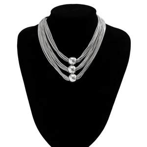 Detail view of multi-layered silver metal box chain necklace with spherical bead charms