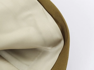 Detailed view of smooth beige satin lining and brown fabric piping inside the blazer