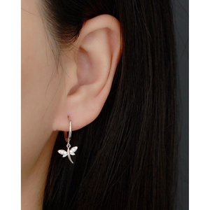 Detail of silver dragonfly hoop earrings with sparkling cubic zirconia on a model