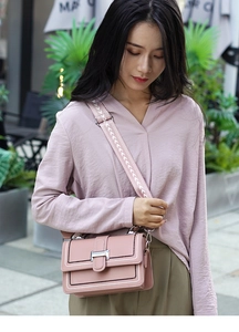 Detail of macaron pink shoulder bag with contrast stitching and wide geometric strap
