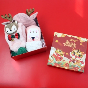 Detail of pink knitted reindeer hat and festive accessories in a red Christmas gift box