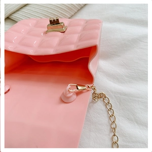 Detail view of pink quilted jelly bag interior with gold metal chain and twist lock clasp