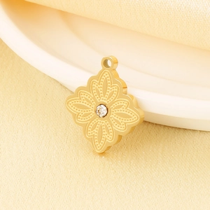 Macro detail of a golden clover pendant with micro-inlaid diamond and vintage floral pattern