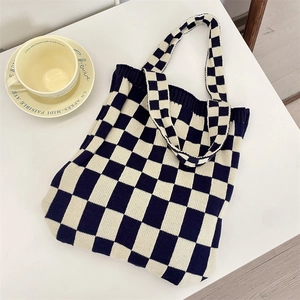 Flat lay of a knitted checkerboard tote bag with soft texture and wide handle