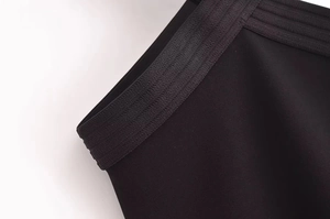 Gros plan détaillé de la texture du tissu de la robe dos nu noire et des coutures