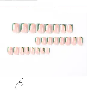 Short square press-on nails with green geometric tips and gold line details on white background