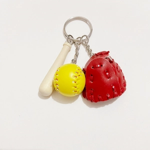 Detailed close-up of a baseball keychain with mini wooden bat, yellow ball, and red glove