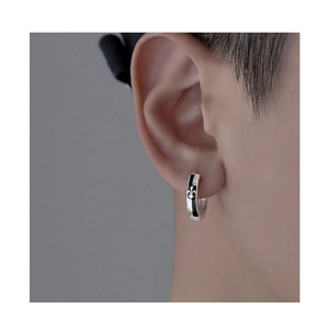 Detail of silver S925 earring with black enamel iris pattern on male model ear