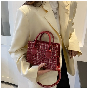 Red tweed handbag with gold hardware shown on a model in a beige blazer suit