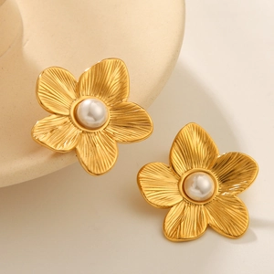 Elegant 18k gold floral earrings with pearls and brushed metal finish on a ceramic tray
