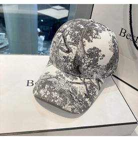 Detail showing white baseball cap with black forest print on a premium gift display box