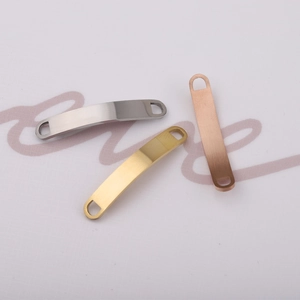 Macro shot of curved stainless steel rectangle connectors in silver, gold, and rose gold