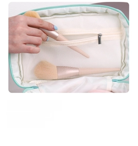 Detail of mint green makeup bag featuring interior mesh zipper pocket for storage
