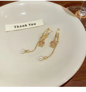 Detailed shot of tulip flower earrings with pearls and long tassels on a ceramic dish