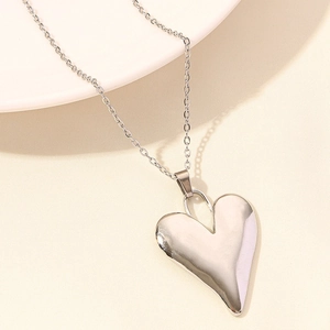 Detailed view of polished heart-shaped silver pendant on a delicate link chain necklace