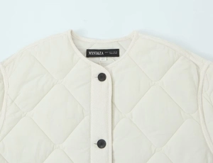 Detailed close-up of quilted cotton jacket neckline and textured fabric with inner tag