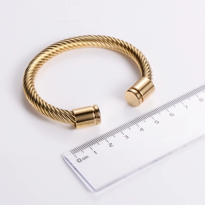 Macro shot of gold stainless steel cable bracelet with ruler showing 6cm diameter size
