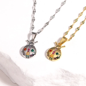 Detailed view of gold and silver ladybug necklaces with colorful zircon stones