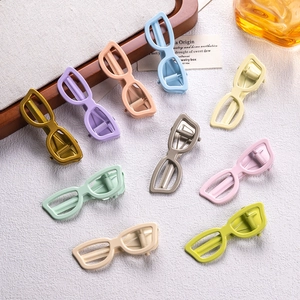 Close-up of colorful sunglasses-shaped hair clips in various pastel acrylic finishes