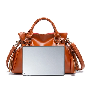 Comparación de tamaño de bolso retro grande de cuero suave mostrado con una tableta