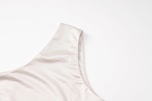 Close-up of champagne satin shoulder strap showing silk texture on a long bodycon dress