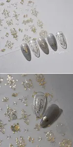 Macro detail of gold Baroque style heart and floral nail stickers on almond nail tips