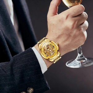 Montre automatique dorée pour homme avec dragon sculpté et cadran squelette au poignet