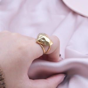Minimalist geometric gold open ring for women shown on a model with elegant pink silk background