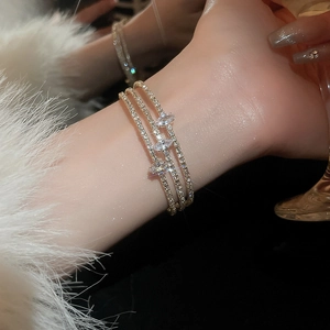 Detail of a triple-layered gold bracelet with marquise and round cubic zirconia stones