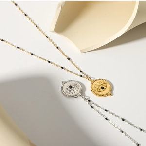 Detail of gold and silver Evil Eye necklaces with black cubic zirconia on fine beaded chains