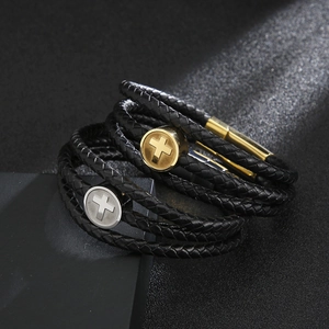 Macro detail of multi-layer braided leather bracelets with silver and gold metal crosses