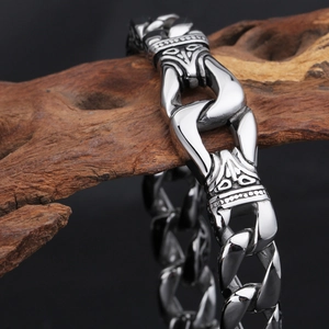 Detailed close-up of retro silver stainless steel bracelet with geometric patterns on wood