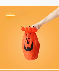 Detail showing bright orange polyester Halloween pumpkin treat bag with smiling face