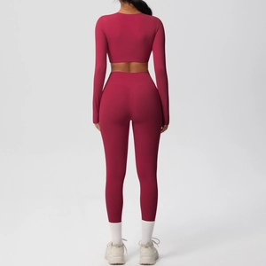 Detail view of red high-waist seamless leggings and long sleeve cropped yoga set back design