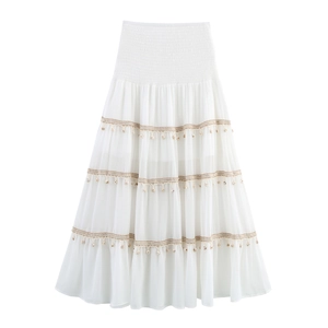 Detailed view of elastic smocking waist and layered ruffle skirt with tassels and shells