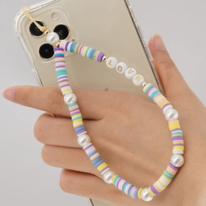 Detail of colorful polymer clay bead phone strap with pearls and gold LOVE lettering