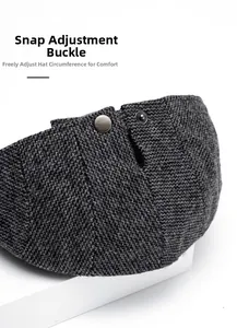 Close-up of adjustable metal buckle and herringbone tweed fabric on gray beret cap
