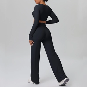 Side view of a black two-piece yoga set with long sleeve crop top and wide leg pants