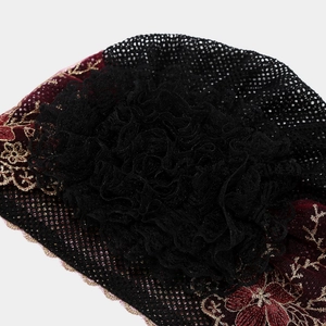 Detailed view of floral embroidery and handmade lace flower on a vintage turban hat