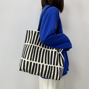 Modern canvas tote bag with black and white pattern shown on model for daily commuting