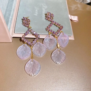 Detail view of purple resin flower petal earrings with sparkling diamond fringe tassels