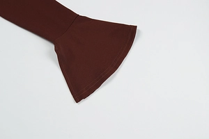 Detail of flared sleeves and fine stitching on a deep burgundy side-slit maxi dress