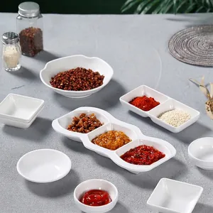 White A5 melamine dipping sauce dishes in various round and square compartments for catering