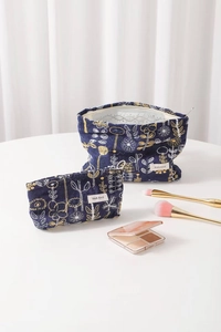 Detailed embroidery on blue cotton linen cosmetic bags featuring floral patterns