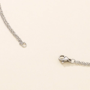 Close-up of stainless steel O-chain necklace with lobster clasp detail in silver finish